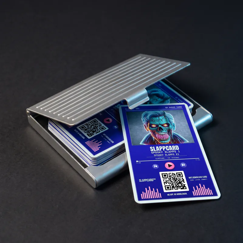 A ribbed metal card holder open on a dark surface, holding a stack of Slappcards with one card slid out